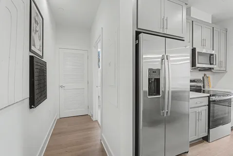 a kitchen with kitchen island white cabinets and stainless steel appliances