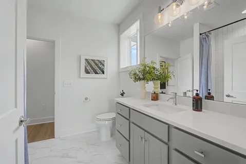 a bathroom with a toilet sink and mirror