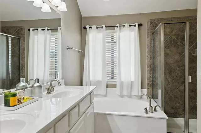 a bathroom with a granite countertop sink and a bathtub