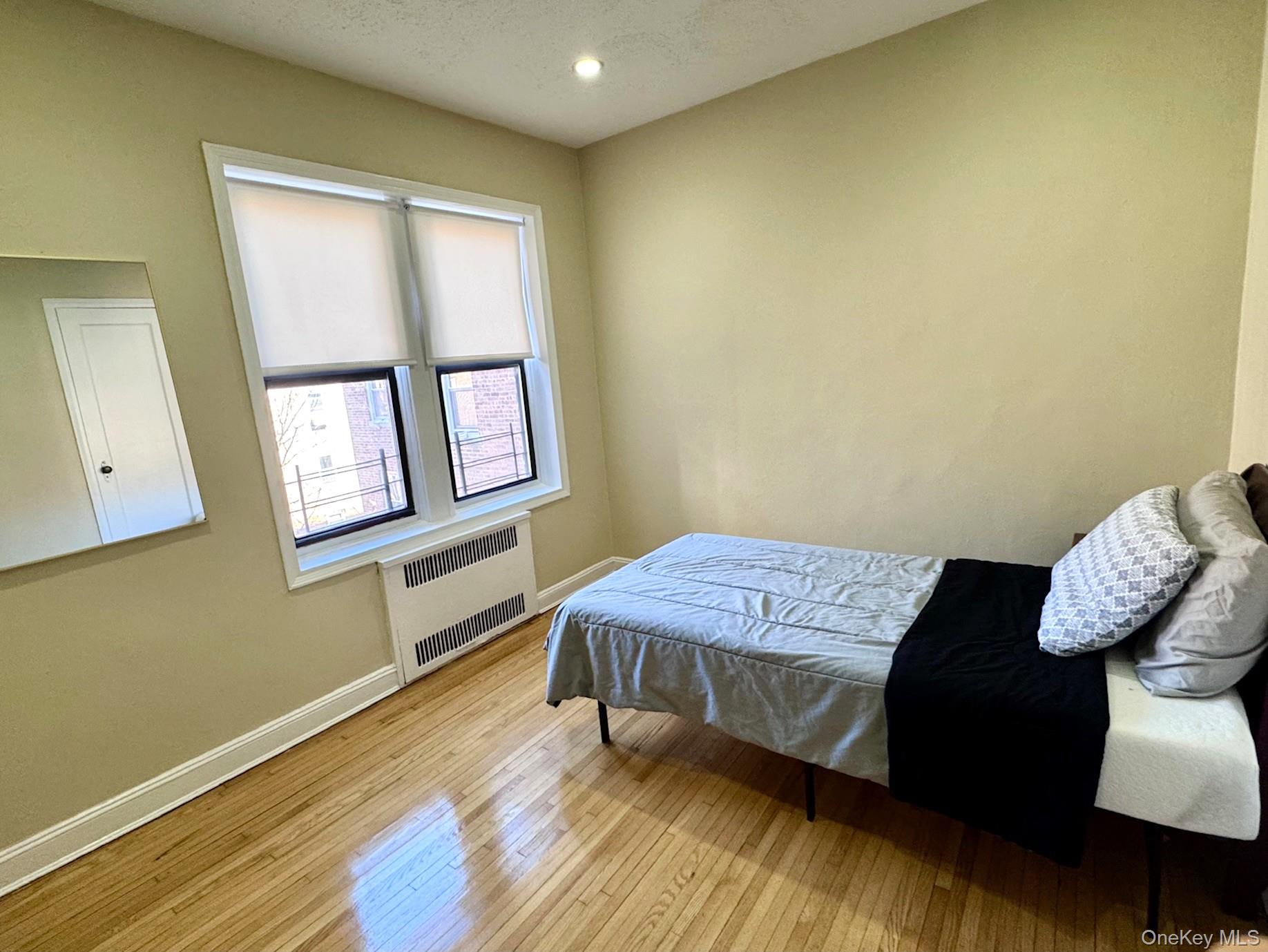 110-35 72nd Road, Unit 503 Queens, NY 11375 - Photo 12 of 15 a bedroom with a bed and wooden floor