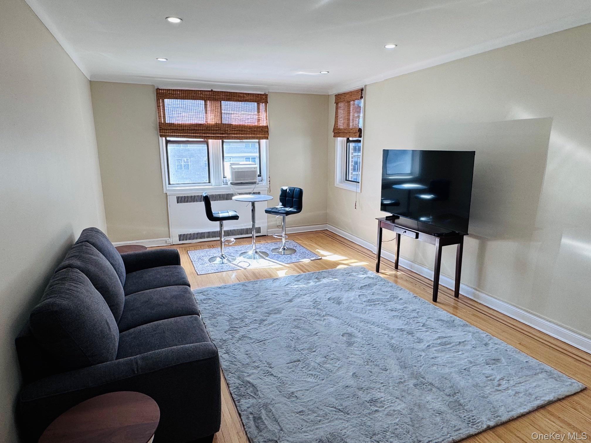 110-35 72nd Road, Unit 503 Queens, NY 11375 - Photo 4 of 15 a living room with furniture and a flat screen tv