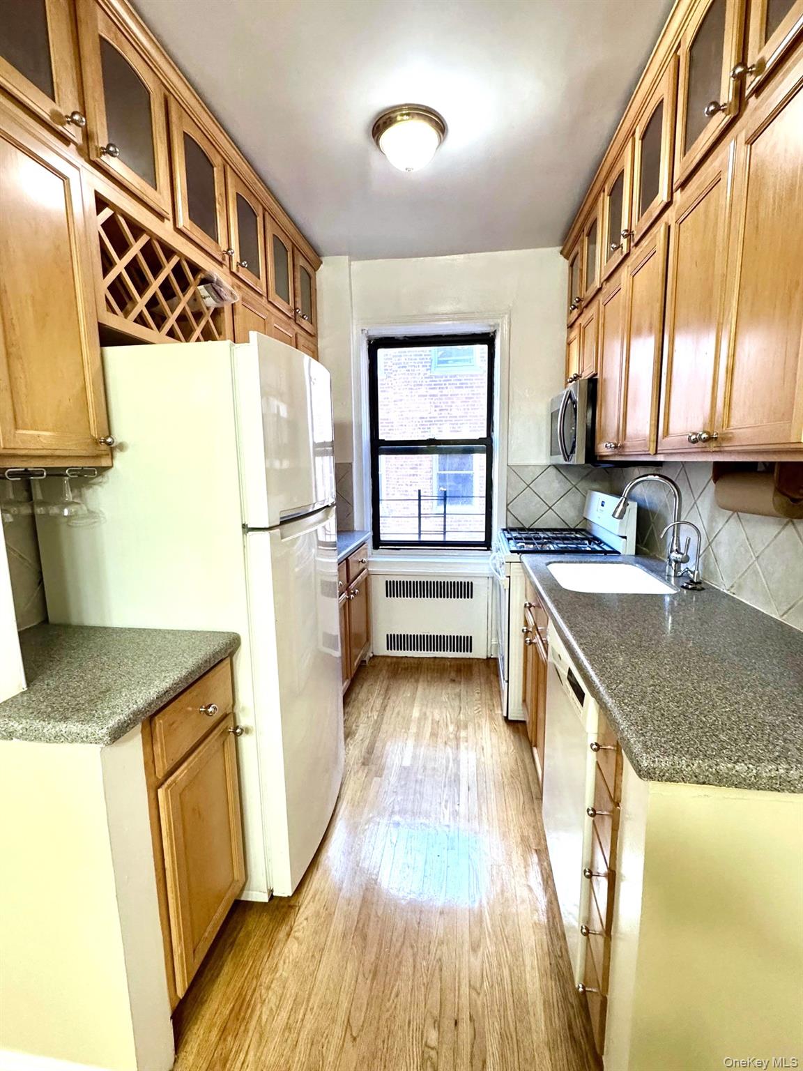 110-35 72nd Road, Unit 503 Queens, NY 11375 - Photo 6 of 15 a kitchen with granite countertop a sink a counter top space and stainless steel appliances