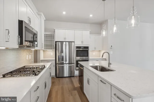 a kitchen with refrigerator a sink and white cabinets