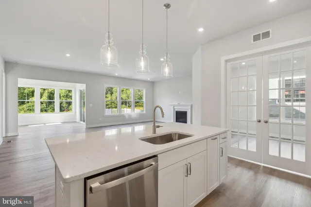 a kitchen with stainless steel appliances granite countertop a sink a oven and a granite counter tops with white cabinets