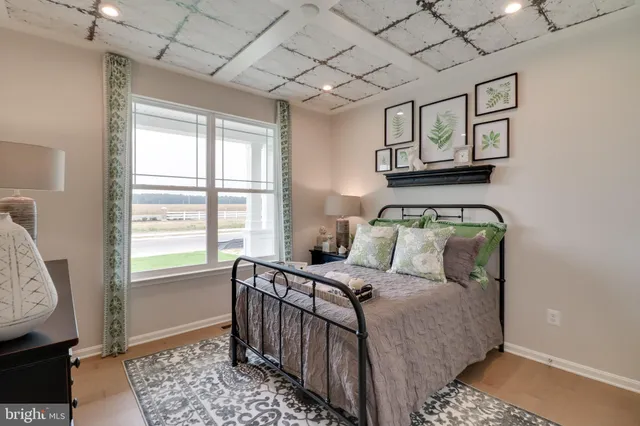 a bedroom with a bed a mirror on dresser and a window