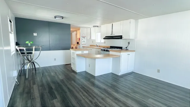 a kitchen with a sink a stove cabinets and wooden floor