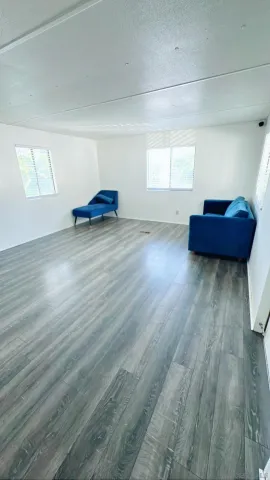a view of a room with wooden floor and a window