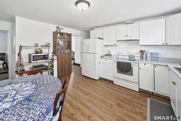 a kitchen with stainless steel appliances sink stove refrigerator and wooden floor