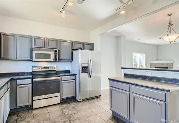 a kitchen with stainless steel appliances granite countertop a refrigerator and a stove top oven