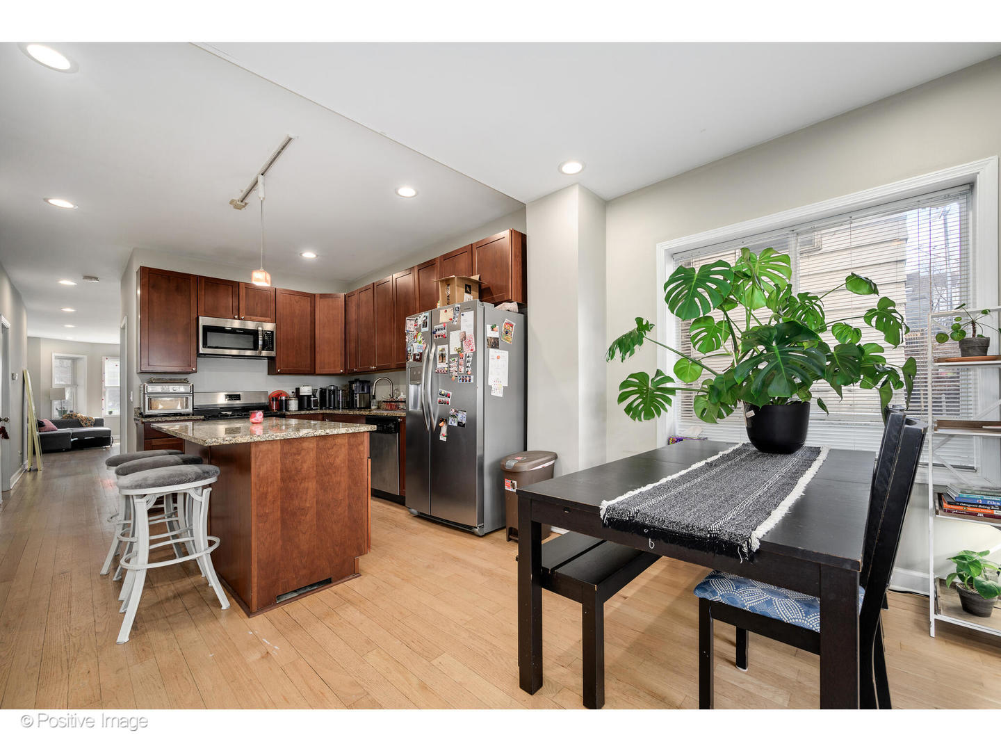 1330 West Roscoe Street Chicago, IL 60657 - Photo 16 of 26 a kitchen with stainless steel appliances kitchen island granite countertop a table chairs and a refrigerator