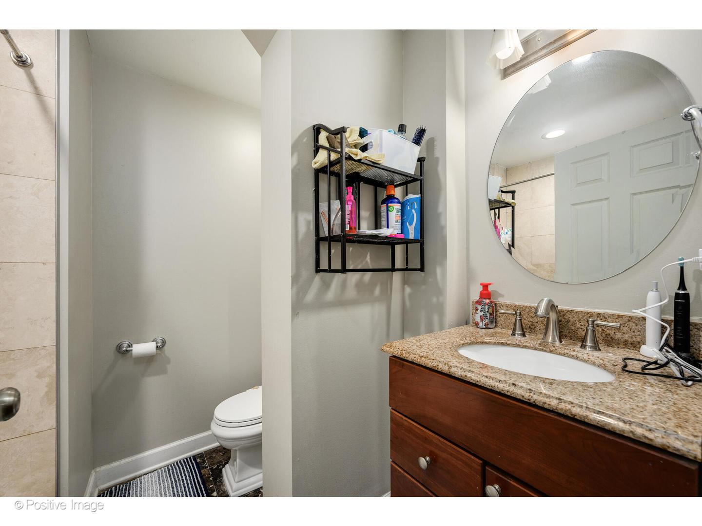 1330 West Roscoe Street Chicago, IL 60657 - Photo 24 of 26 a bathroom with a granite countertop sink a toilet and a mirror