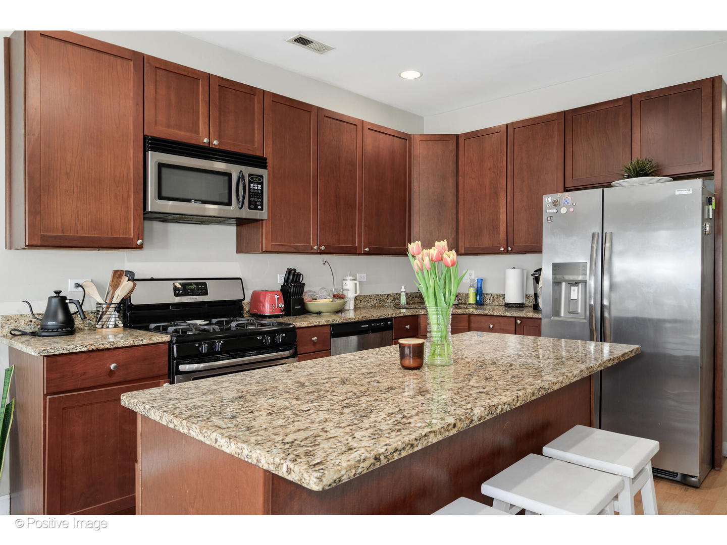 1330 West Roscoe Street Chicago, IL 60657 - Photo 6 of 26 a kitchen with stainless steel appliances granite countertop a stove refrigerator and microwave