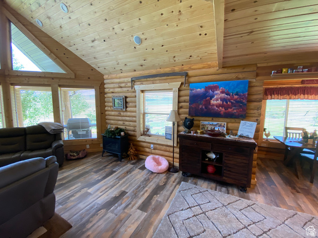 79 Auburn Forest Road Auburn, WY 83111 - Photo 23 of 76 Living area featuring a vaulted wood ceiling, healthy amount of natural light, dark wood-style floors, and log walls