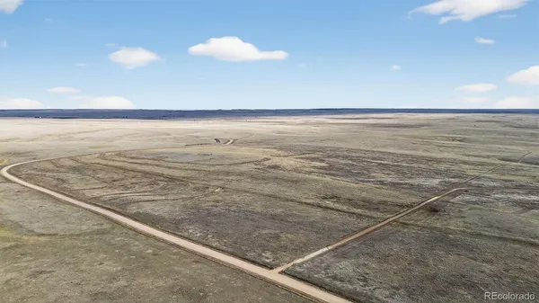 a view of water heater and a room with wooden floor