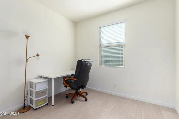 a view of a workspace with furniture and a window