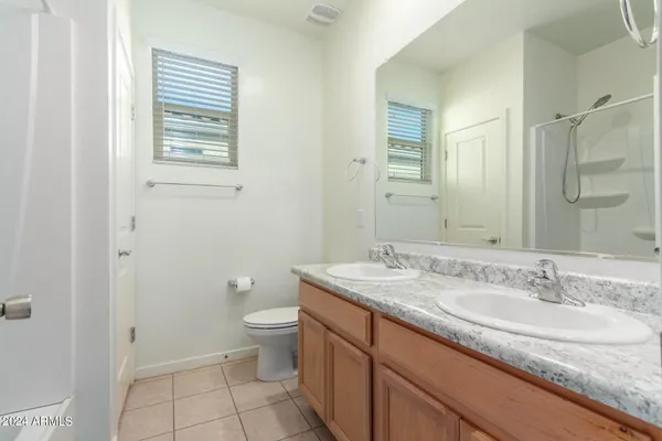 a bathroom with a granite countertop sink a toilet and a mirror