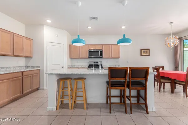 a kitchen with stainless steel appliances granite countertop a table and chairs in it