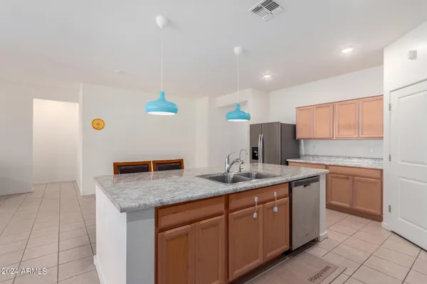 a kitchen with stainless steel appliances granite countertop a sink and a refrigerator