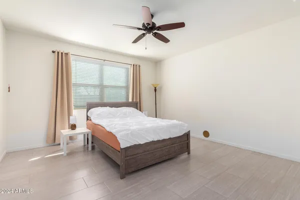 a bedroom with a bed and a ceiling fan