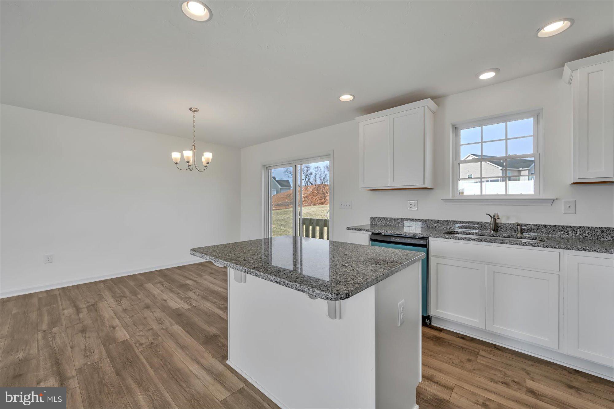 24 Meadow Lane, Unit 18 Hanover, PA 17331 - Photo 9 of 21 a kitchen with granite countertop a sink stainless steel appliances white cabinets and wooden floor