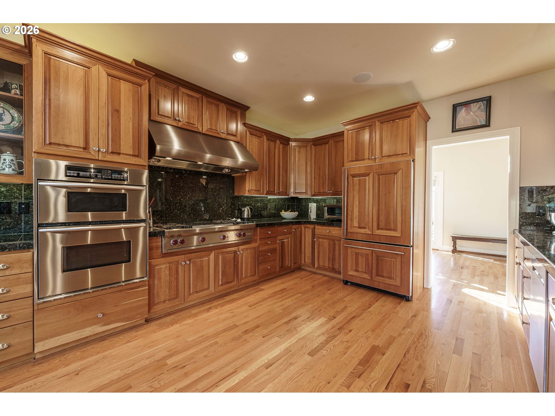 19121 Northwest 61st Avenue Ridgefield, WA 98642 - Photo 10 of 39 a kitchen with granite countertop a refrigerator and wooden floor