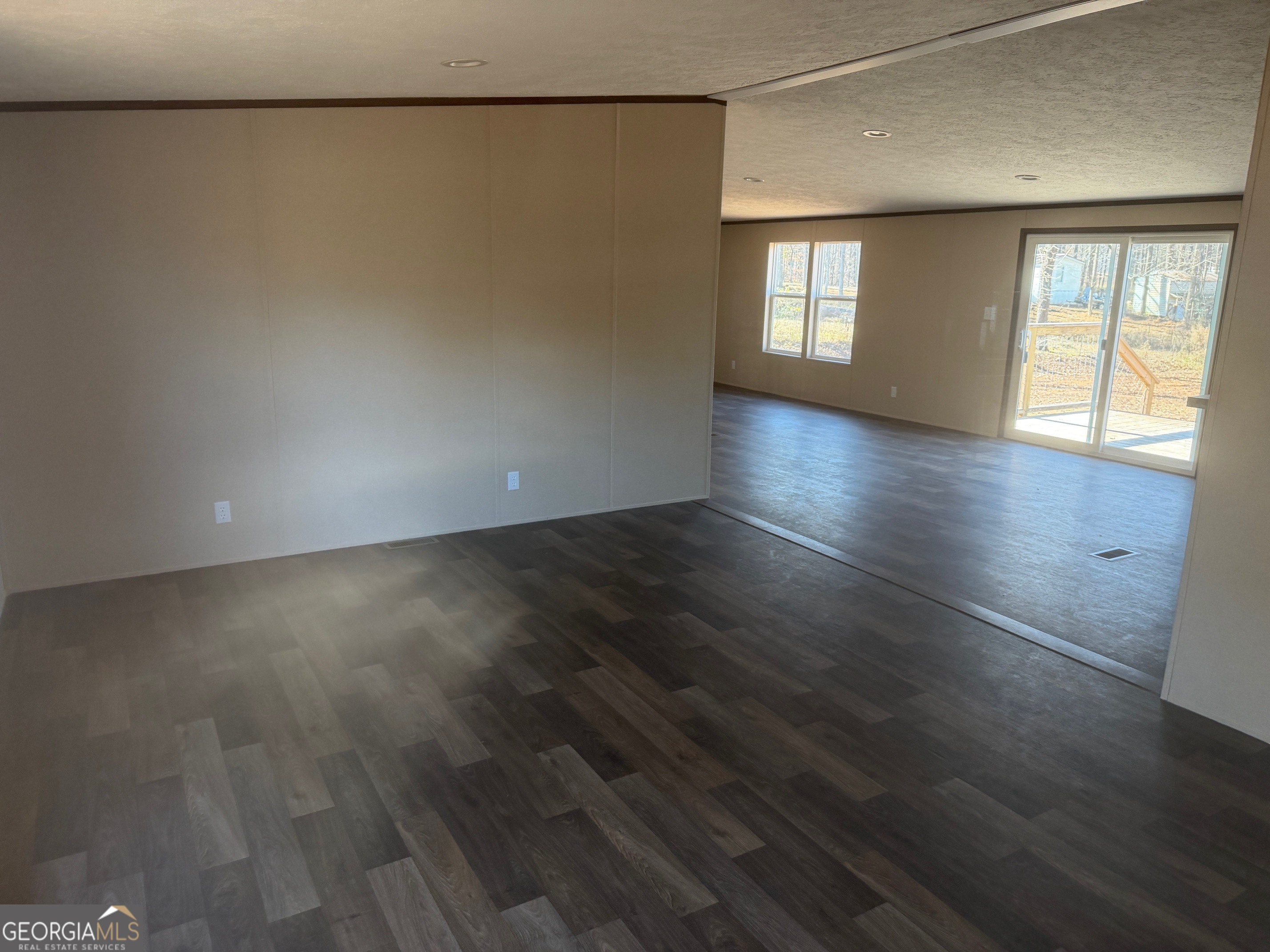 832 Stone Stewart Road Hull, GA 30646 - Photo 3 of 15 an empty room with wooden floor and windows with curtains
