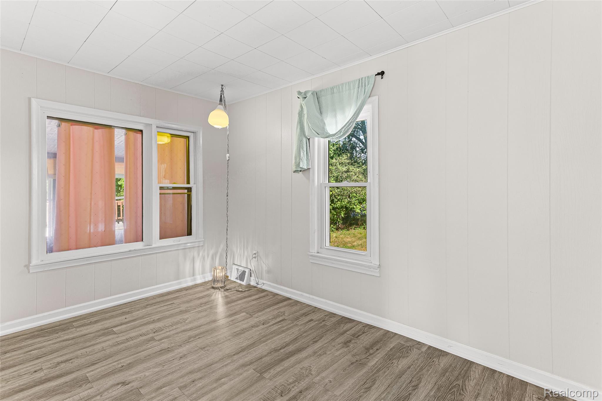 2550 Loon Lake Road Wixom, MI 48393 - Photo 17 of 36 Wood-finish flooring, white panel walls, and multiple windows