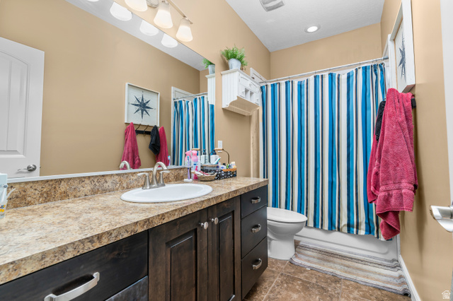5702 950 North Ogden, UT 84404 - Photo 22 of 36 Bathroom featuring a dark wood-finish vanity with a laminate countertop, an undermount sink, and a chrome-finish faucet