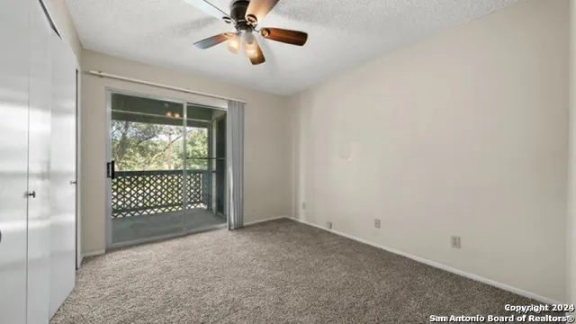 a view of a room with a ceiling fan and a window