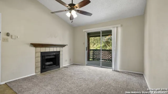 an empty room with windows and fireplace
