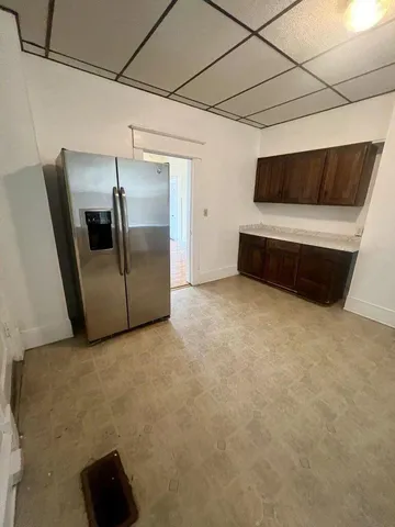 a living room with a couch and a refrigerator