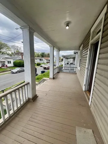 a view of a porch with wooden floor and furniture