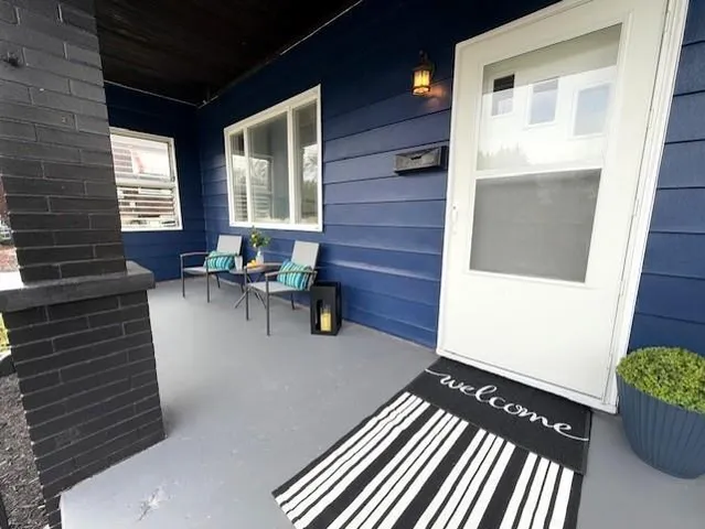 a balcony with chairs and with potted plants