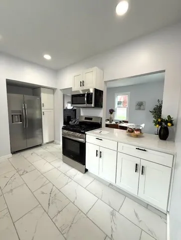 a kitchen with granite countertop a cabinets and steel appliances