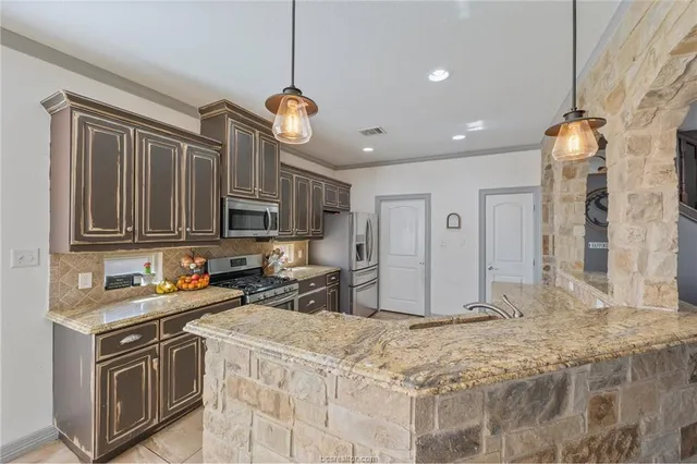 a kitchen with stainless steel appliances granite countertop a sink stove and refrigerator