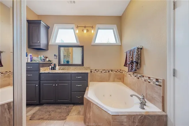 a bathroom with a tub sink and mirror