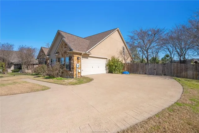 a view of a white house with a yard and wooden fence