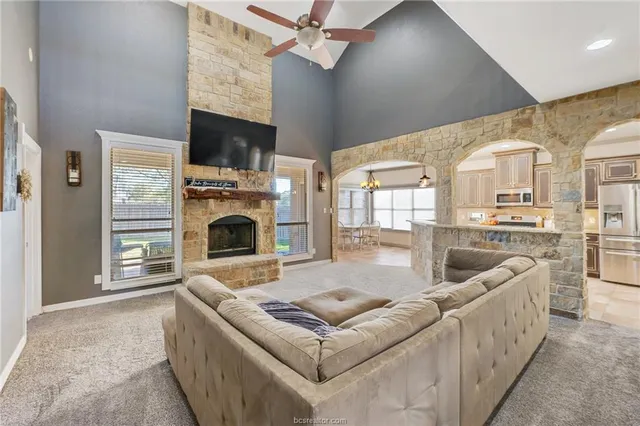 a living room with furniture a fireplace and a flat screen tv