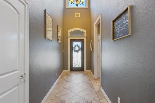 a view of a hallway with entryway window and front door