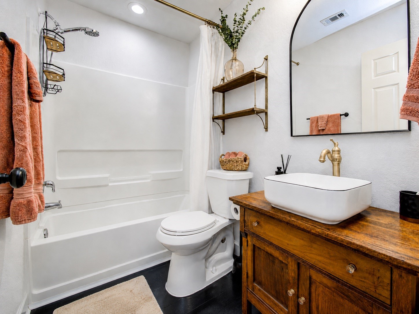8647 Suburban Oaks Road Houston, TX 77093 - Photo 12 of 21 The primary bath features a tub and shower surround, light walls, and a warm wood vanity. (photo has been enhanced for marketing purposes)