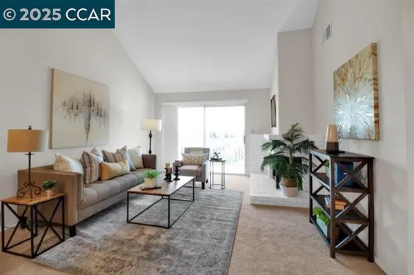 a living room with furniture and a potted plant