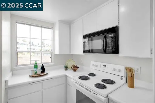a kitchen with a sink a stove and cabinets