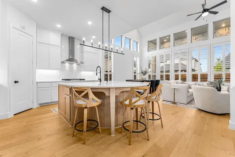a kitchen with stainless steel appliances kitchen island granite countertop a table chairs and a refrigerator
