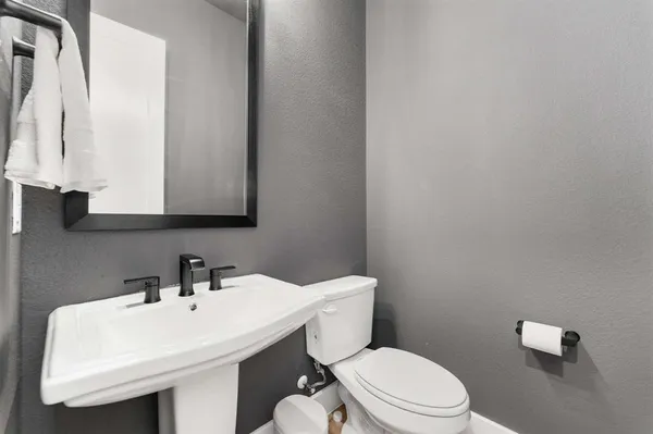a bathroom with a sink a toilet and mirror
