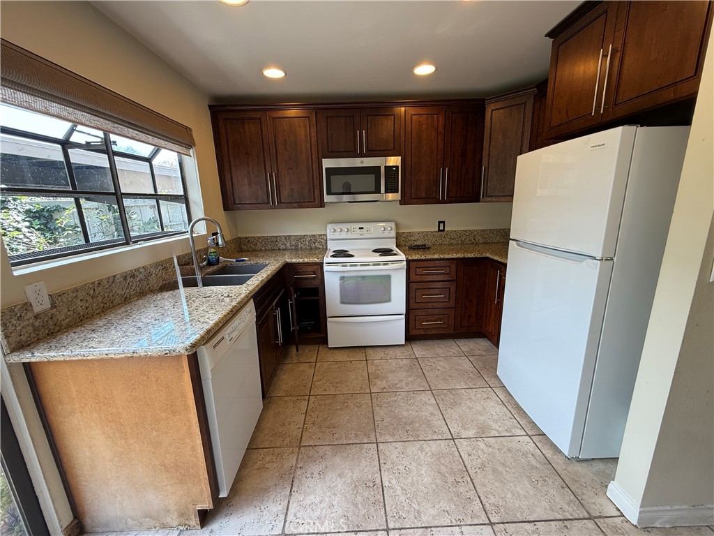 229 Springview Irvine, CA 92620 - Photo 7 of 16 a kitchen with a refrigerator a stove top oven and a sink