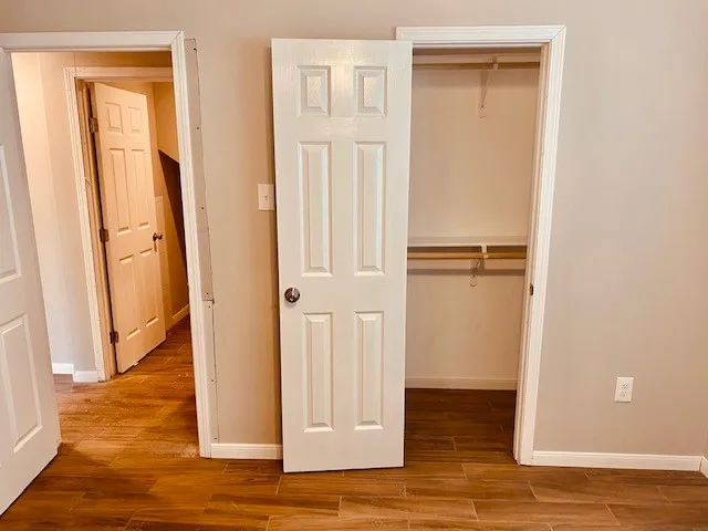 an empty room with wooden floor and closet