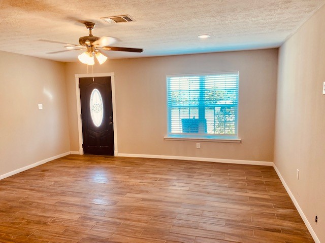 1602 Henninger Street Houston, TX 77023 - Photo 2 of 20 an empty room with wooden floor fan and windows
