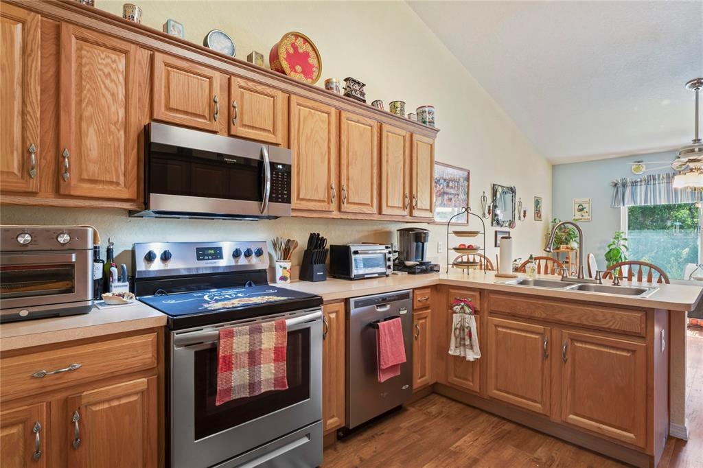 9086 Manchester Street Spring Hill, FL 34606 - Photo 13 of 50 a kitchen with granite countertop a stove top oven microwave and cabinets