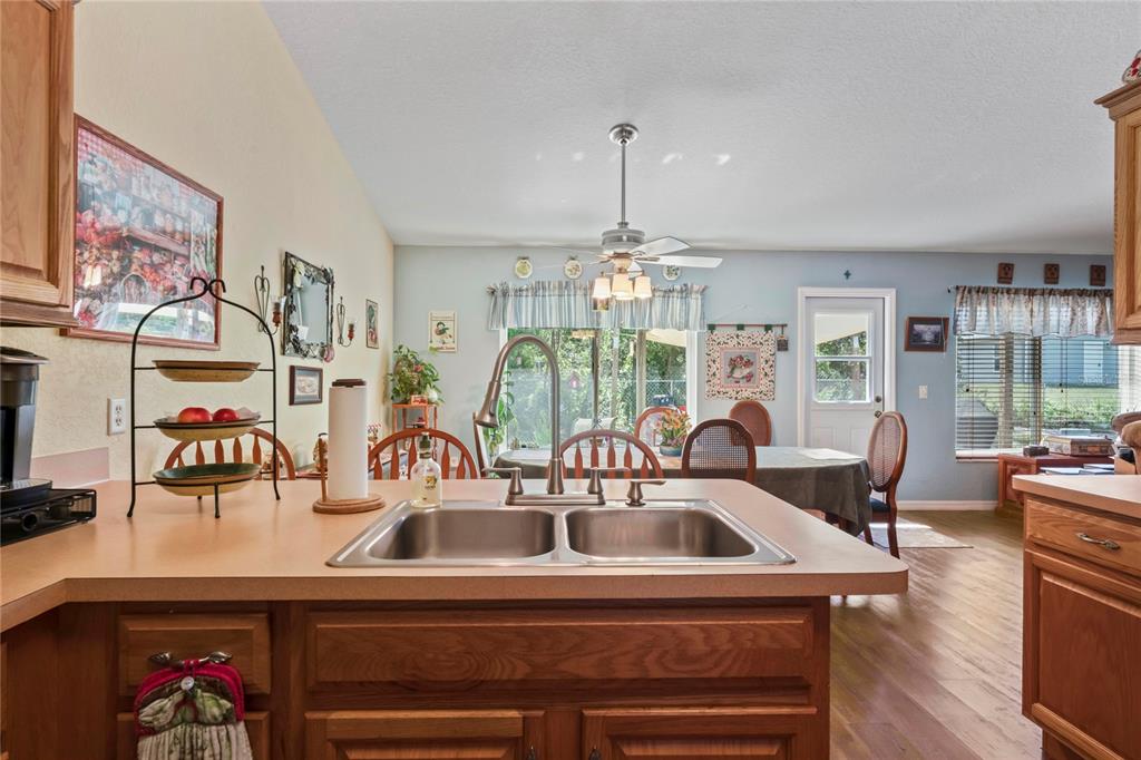 9086 Manchester Street Spring Hill, FL 34606 - Photo 14 of 50 a kitchen with a sink a chandelier and living room view