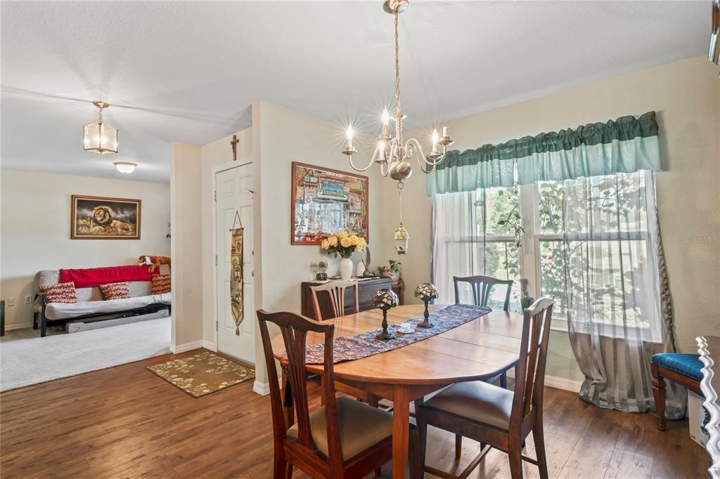9086 Manchester Street Spring Hill, FL 34606 - Photo 20 of 50 a view of a dining room with furniture wooden floor and chandelier
